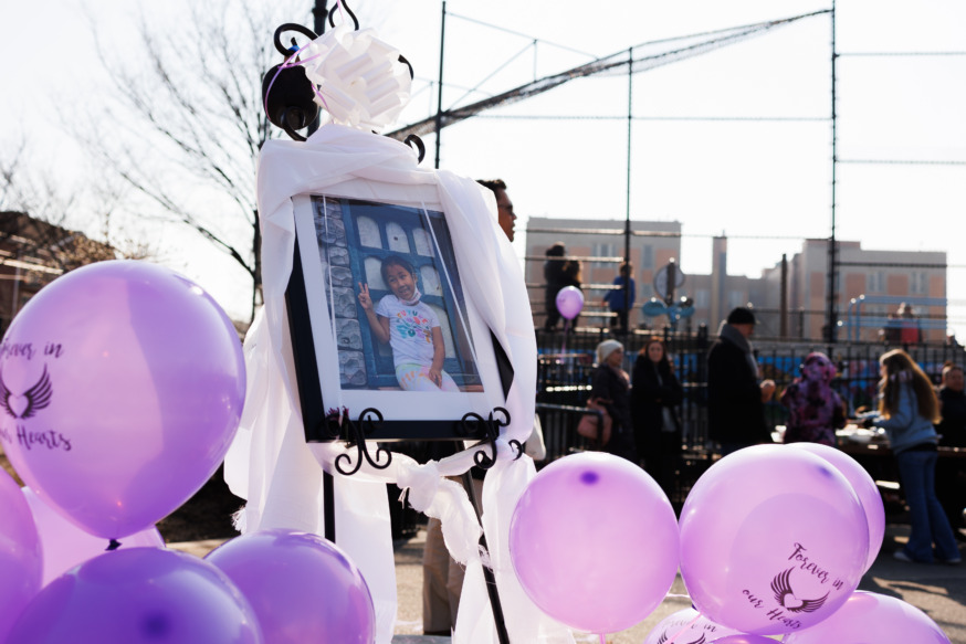 People gather at a memorial for 7-year-old Dolma Naadhun in Astoria Heights Playground. Naadhun was killed by a driver at the corner of Newtown Road and 45th Street.